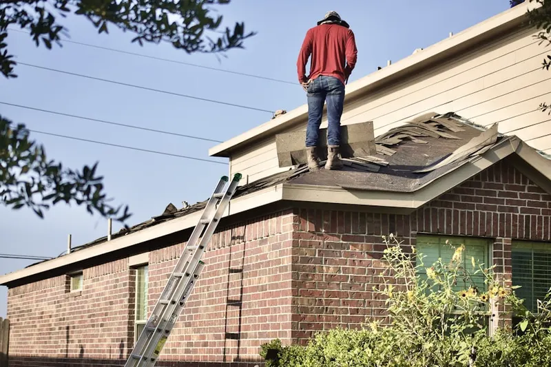 Professional roofer working on a residential roof in Thomas Mill